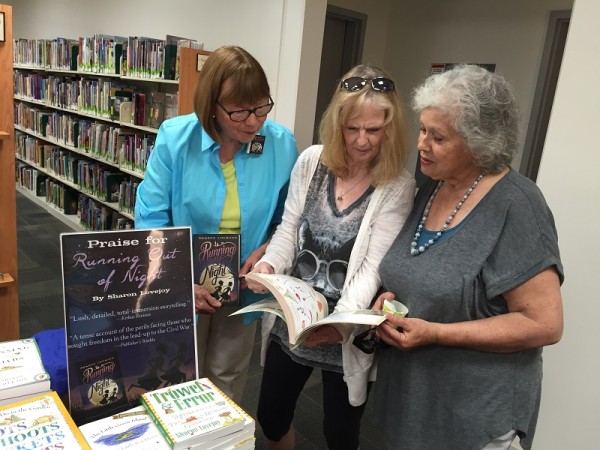 Author Sharon Lovejoy talks to visitors about one of her books at the Atascadero Library's anniversary party Saturday.  Photo by Paula McCambridge.