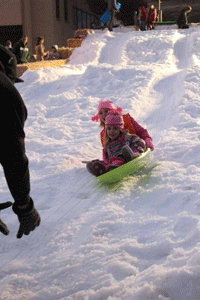 Katie Coombs and Amalia Young go down one of the snow slides together at Winter Wonderland in 2013. Photo by Heather Young