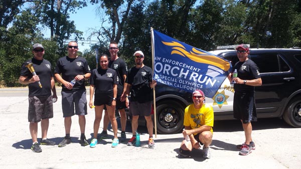 Commander Joe Allen with Atascadero Police Department is on the far right and the gentleman holding the flag is Matt Shuck, a Special Olympic athlete. The person on the far left is Sergeant Caleb Davis from the Atascadero Police Department. The three others are CHP personnel.