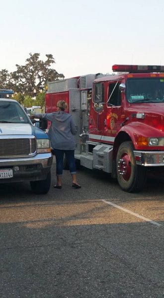 A Girl Scout parent is seen tossing boxes of cookies to passing firefighters. Photo contributed by Jeanne Gard