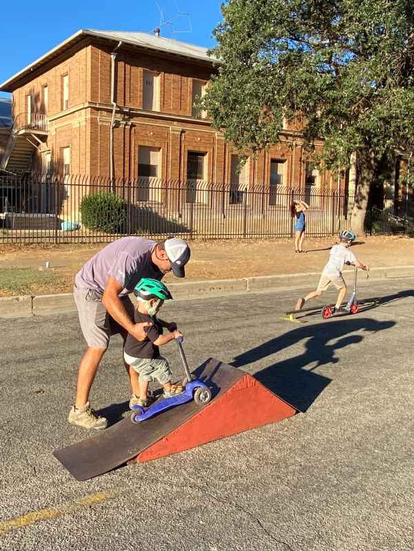 Father helps son over jump