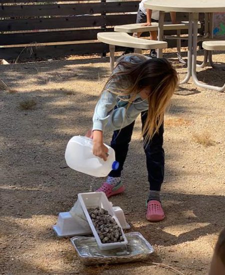A Creston Elementary student pours water during the erosion lesson